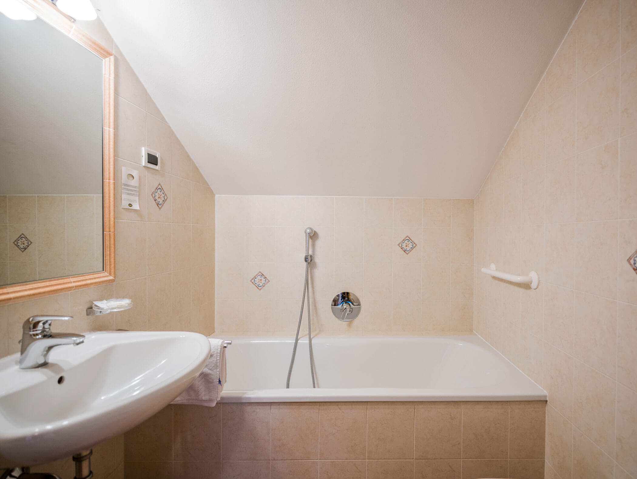 Bathroom with bathtub, washbasin and mirror - Wirtshaushotel Alpenrose
