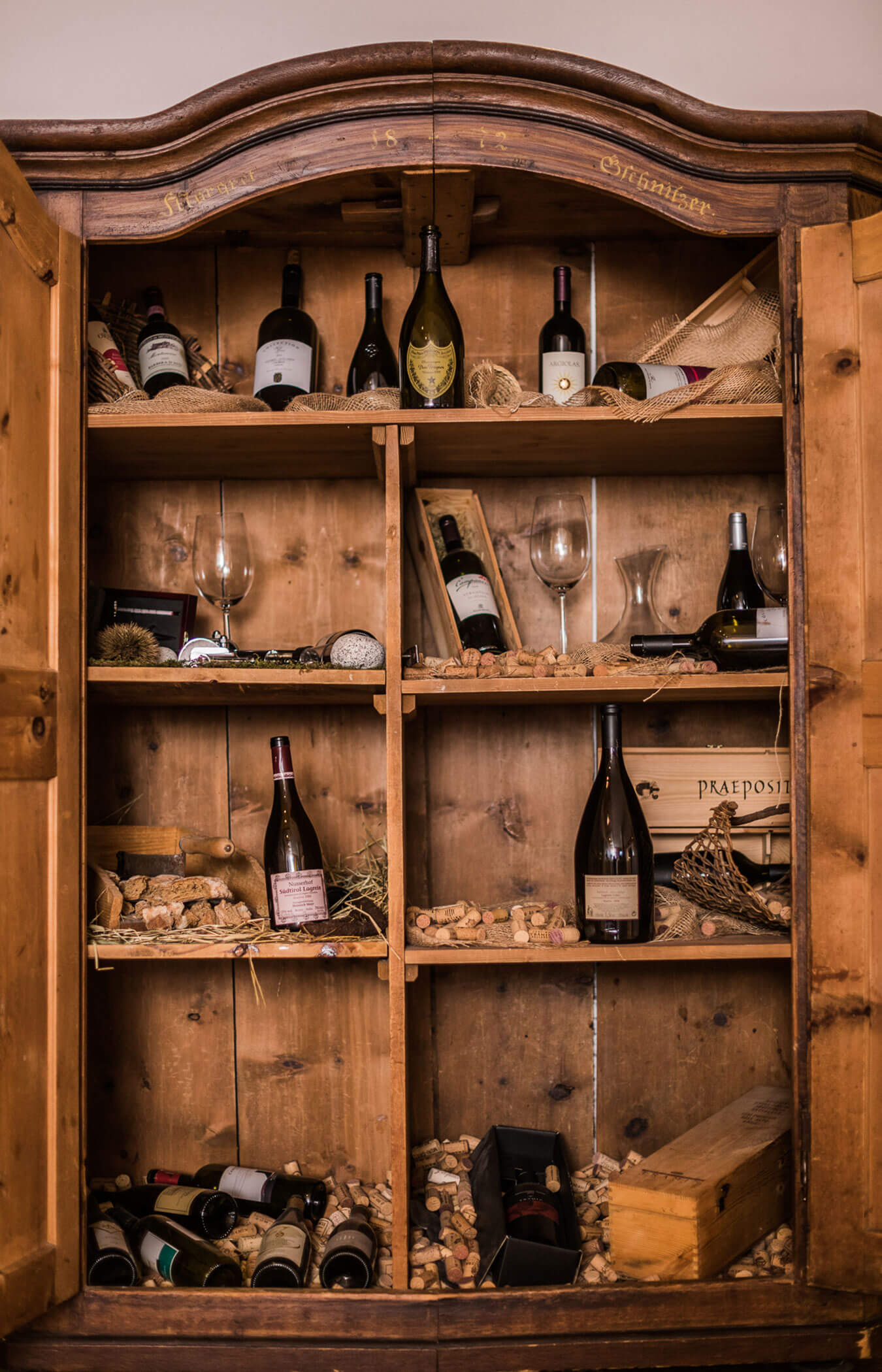 Weinschrank aus Holz mit verschiedenen Weinen darin - Wirtshaushotel Alpenrose