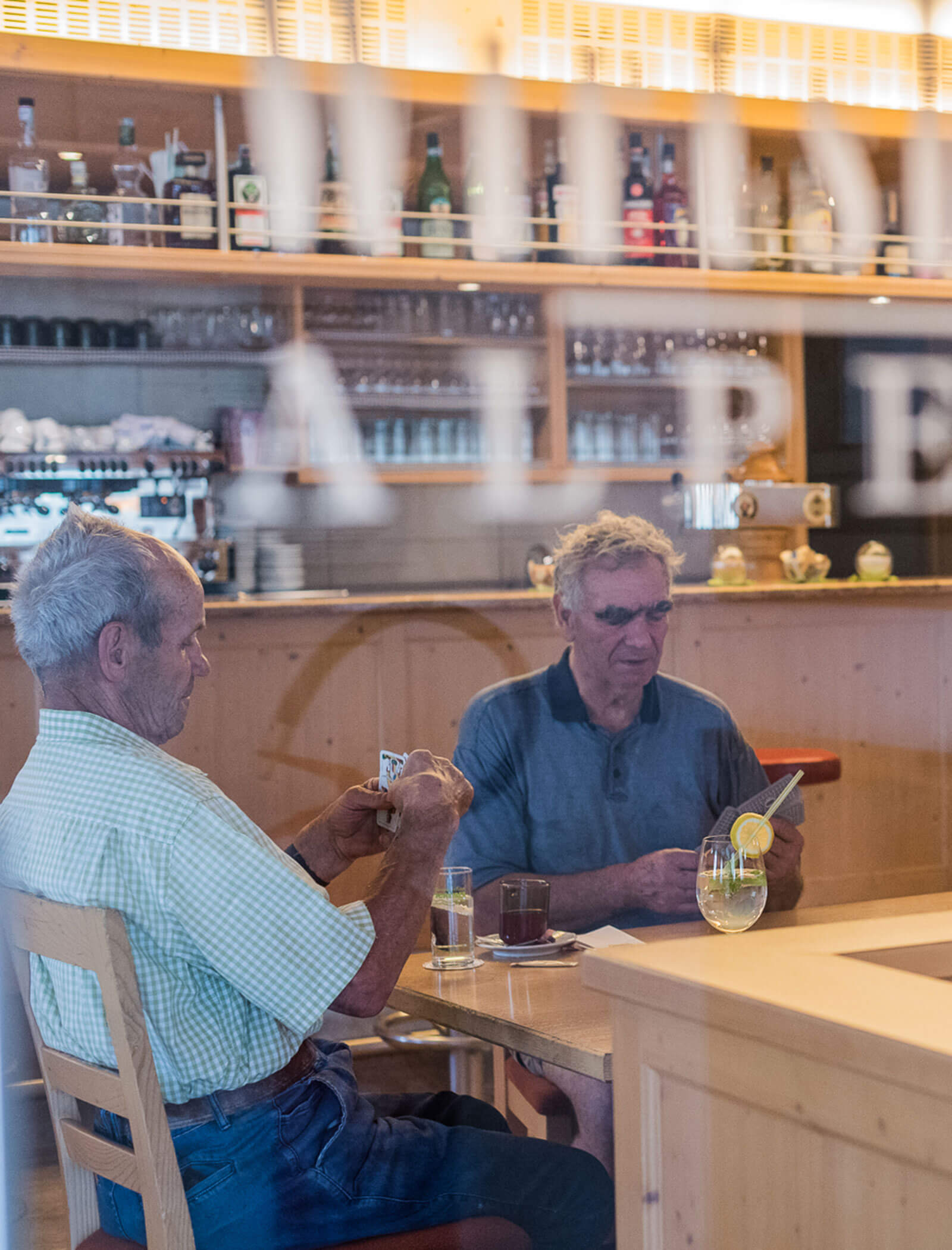 Playing cards at the table, bar in the background - Wirtshaushotel Alpenrose